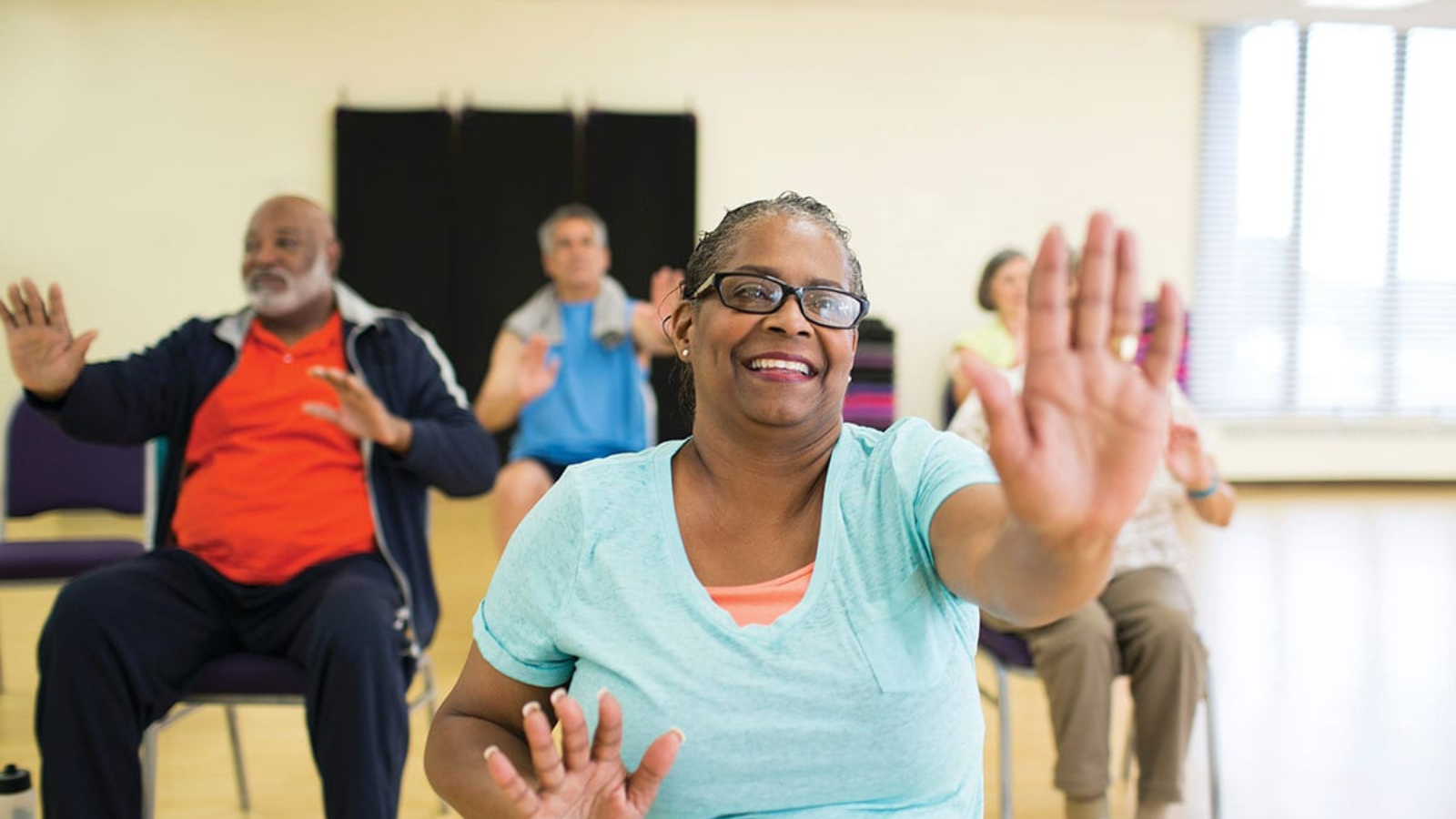 Diverse older adults exercise in a fitness class.