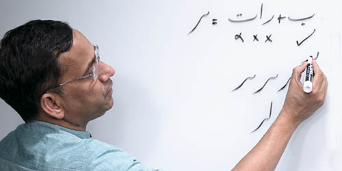 photo of man drawing script on whiteboard