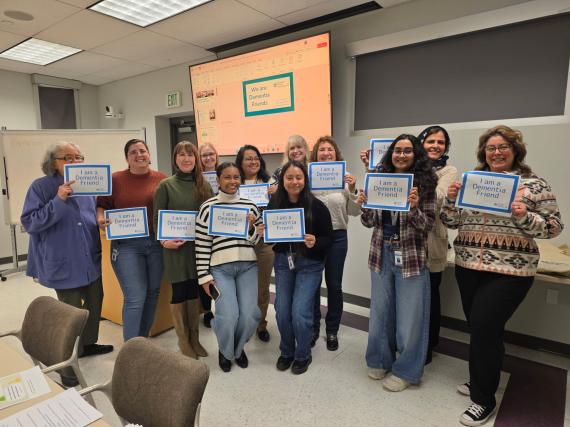 Twelve adults of the Benton Franklin Health District staff hold up Dementia Friends certificates