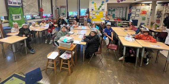 Kids in a classroom wearing brain hats