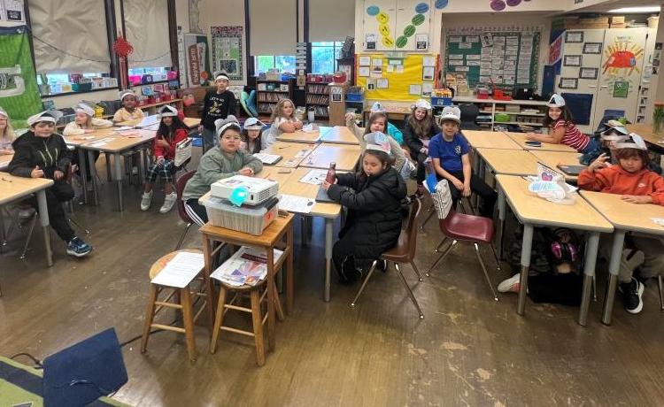 Kids in a classroom wearing brain hats
