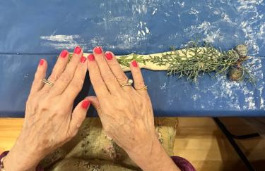 Woman's hands working with clay and herbs