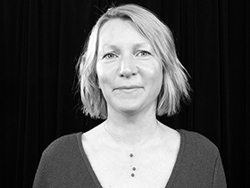 A white woman with chin-length blond hair.