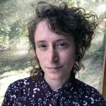 A white-presenting person with short brown curly hair.
