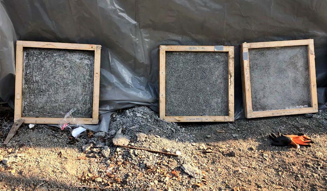 Concrete panels with three different surface preparations for testing bond strength.
