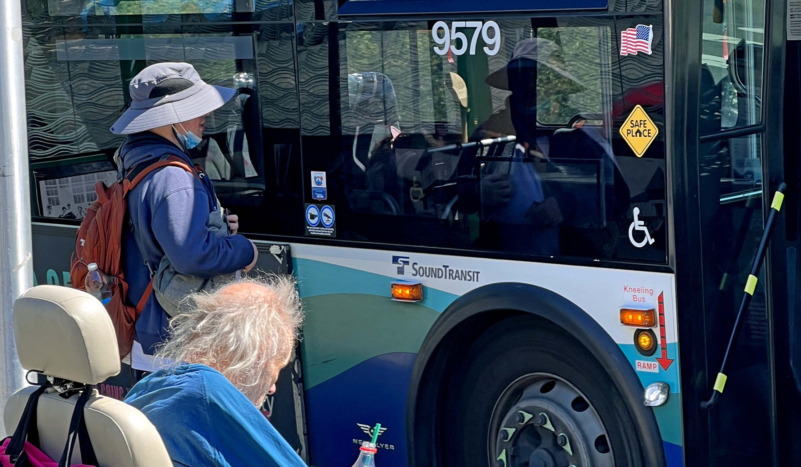 A woman and a man in a wheelchair wait to board a Sound Transit bus