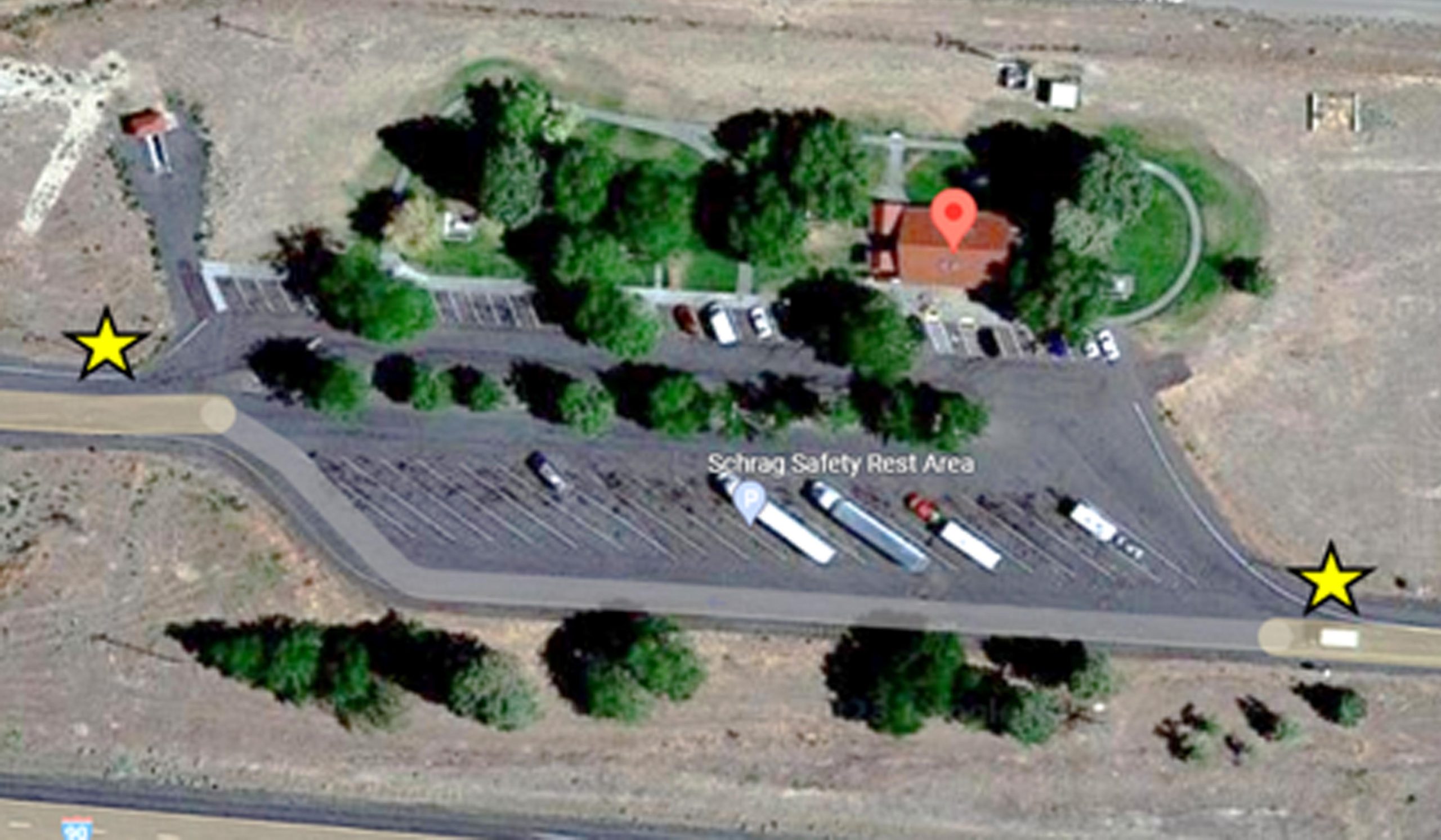 An overhead view of vehicles parked at the Schrag westbound rest stop and entrances and exits shared between passenger vehicles and trucks.
