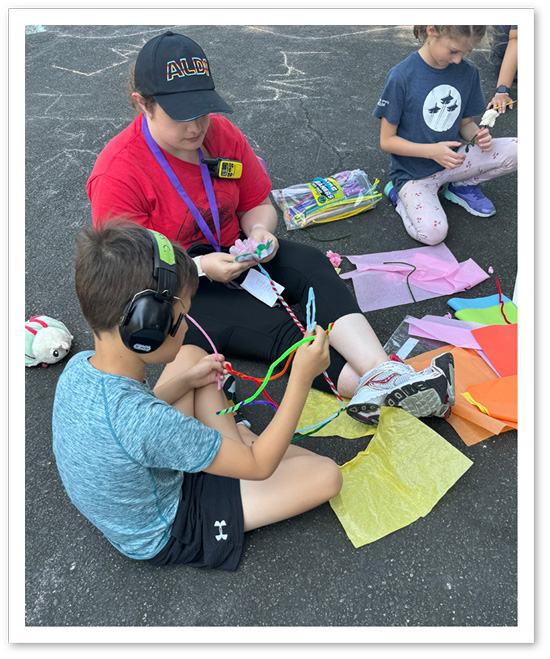 Photo: APEX camp counselor working on a craft project with an APEX camper.