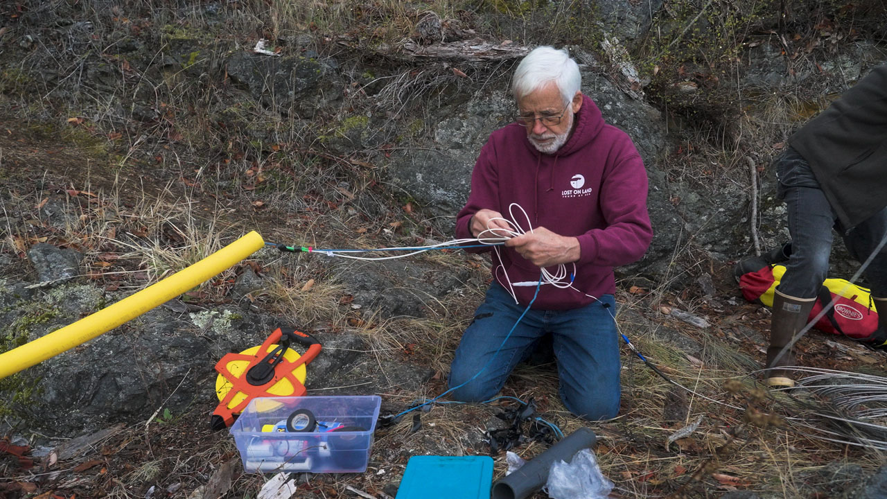 Val Veirs works on tieing cables with his hands