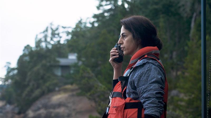 Dr. Abadi on shore holding a walkie-talkie