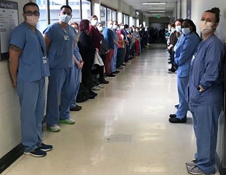 Nurses standing in a corridor looking at the camera.