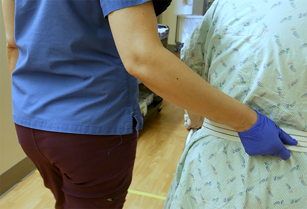 a nurse helping a patient walk