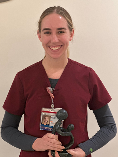 Kate Clore holding her award