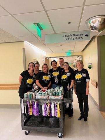 A group of project recharge volunteers smiling with a cart full of goodies