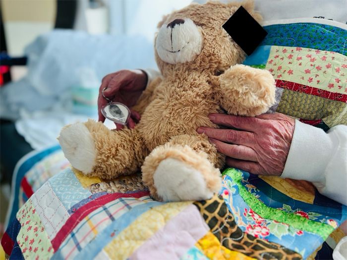 a hand holding a teddy bear