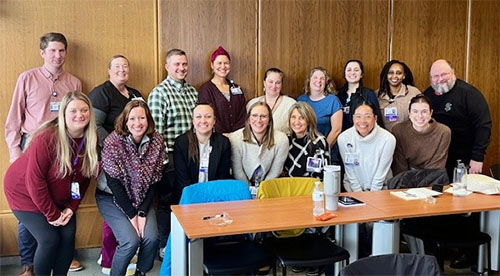 A group of nurse leaders gathered in a conference room posing.