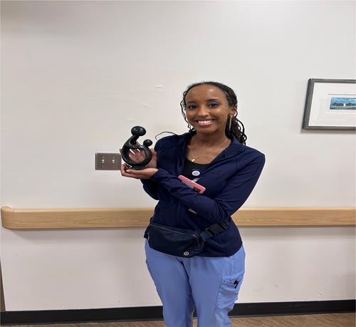 Ayan Mohamed holding her DAISY award.