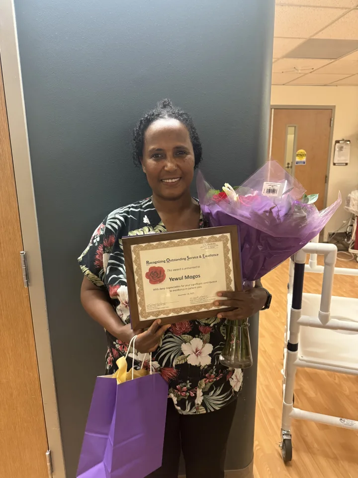 Yewul Mogos holding her ROSE award.