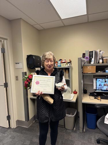 Marina Shpreyregina holding her ROSE award.