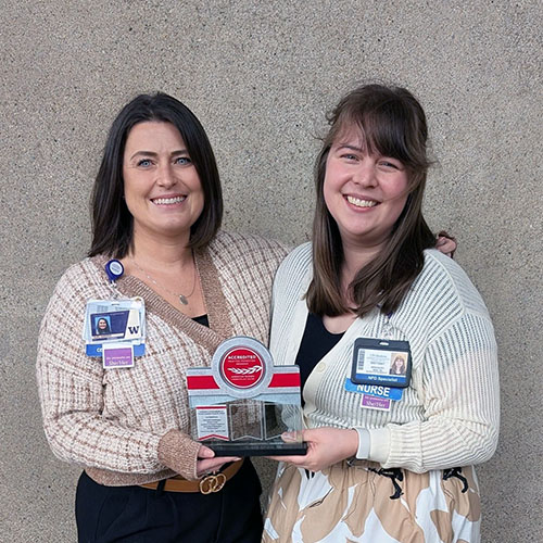 Two nurses holding a PTAP accreditation award