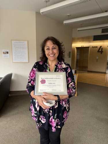 Cathy Lacy holding her ROSE award.