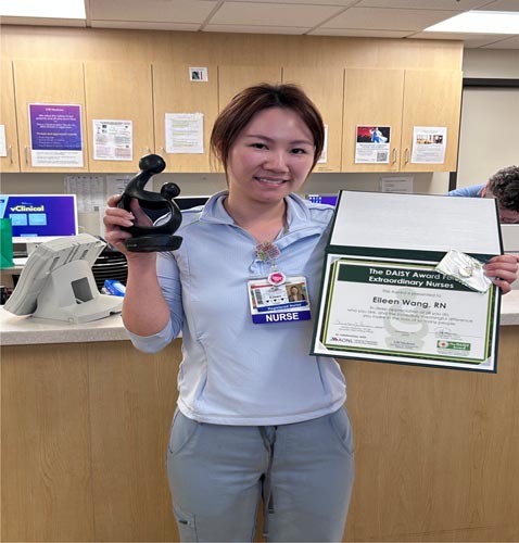 Eileen Wang holding her DAISY award.
