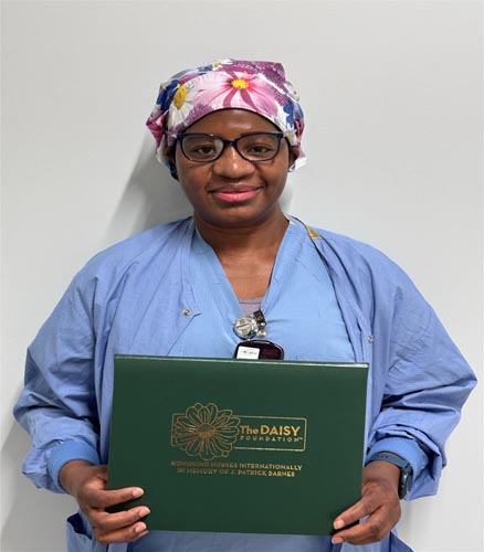 Immy Mukasa holding her DAISY award.