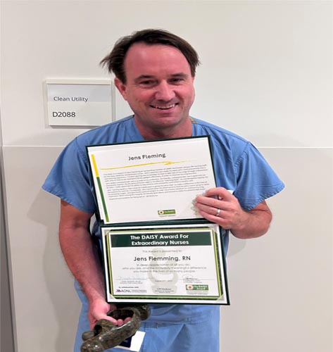 Jens Fleming holding his DAISY award.