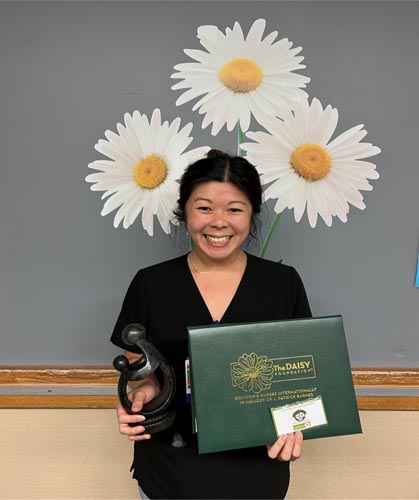 Keri Fong holding her DAISY award.