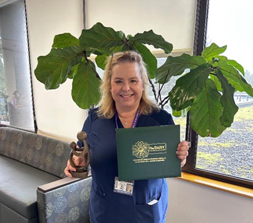 Linda Bakkala holding her DAISY award.