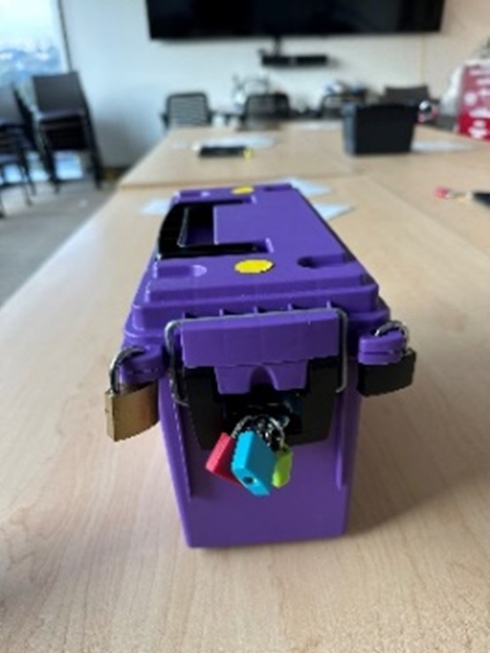 A purple plastic toolbox locked with many locks on a table.