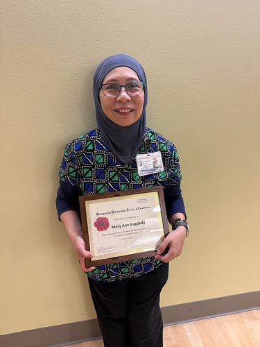 Mary Ann Bagdady holding her ROSE award.