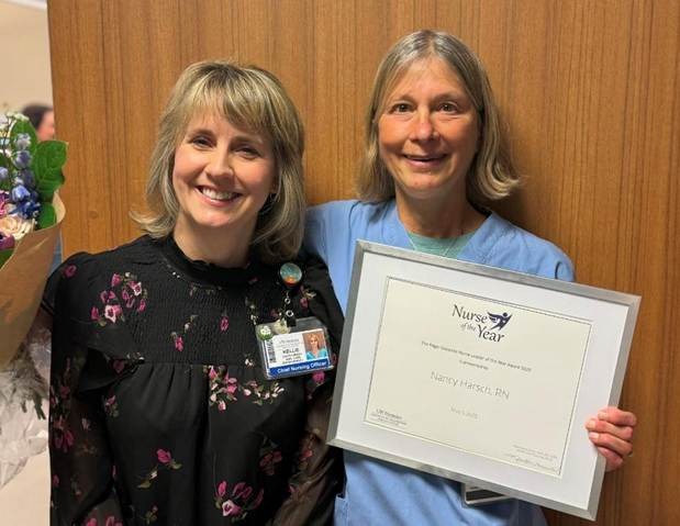 Nancy Harsch holding her framed Nurse of the Year certificate standing next to Kellie Garth Green, CNO.