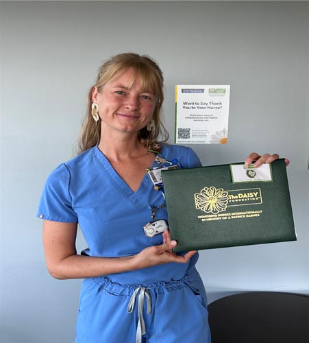Paige Booth holding her DAISY award.