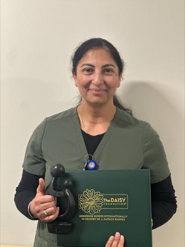 Rupinderjit Kaur holding her DAISY award.